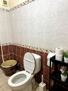 a bathroom with a toilet and a tiled wall at Spacious fantastic closeby airport and city in Marrakesh