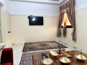 a living room with a table and a flat screen tv at Spacious fantastic closeby airport and city in Marrakesh