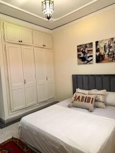 a bedroom with a bed and white cabinets at Spacious fantastic closeby airport and city in Marrakesh