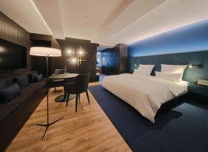 um quarto com uma cama, uma mesa e um sofá em Hotel am Sophienpark em Baden-Baden