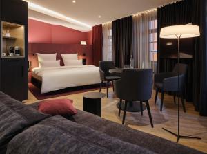 バーデン・バーデンにあるホテル アム ゾフィーンパークのベッドとテーブルが備わるホテルルームです。