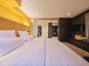 a large bed with white pillows in a bedroom at Hotel am Sophienpark in Baden-Baden