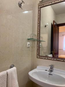 y baño con lavabo y espejo. en Hospedaje Ramos, en Santiago de Compostela