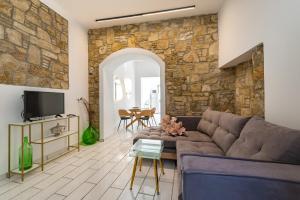 sala de estar con sofá y pared de piedra en Lefka Hotel & Apartments en Rodas