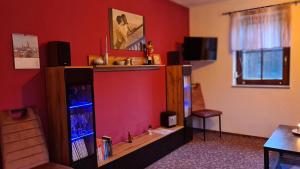 a living room with a red wall with a entertainment center at Wolfsgrund 14 in Dorfchemnitz