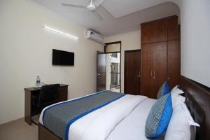a bedroom with a bed and a desk and a television at OYO Surya Palace in New Delhi