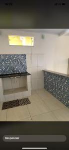 a kitchen with a sink and a tile floor at Kitnet funcional in Angra dos Reis
