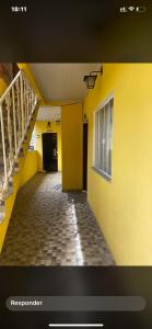 a hallway of a building with a yellow wall at Kitnet funcional in Angra dos Reis