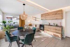 a kitchen and living room with a table and chairs at Bijou Lohnerblick - sonnig mit Terrasse&Bergsicht in Adelboden