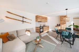 a living room with a couch and a table at Bijou Lohnerblick - sonnig mit Terrasse&Bergsicht in Adelboden +15 photos