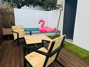 eine Terrasse mit 2 Stühlen und einem rosa Schwan im Pool in der Unterkunft THE CANVAS LONAVLA in Lonavla