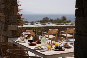 a table with plates of food and drinks on a patio at Summer Senses Luxury Resort in Logaras