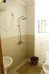 a bathroom with a toilet and a sink at CALBERT LODGE in Abuja