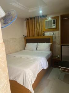 um quarto com uma cama e uma televisão em CALBERT LODGE em Abuja