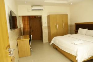 a bedroom with a bed and a television in it at CALBERT LODGE in Abuja