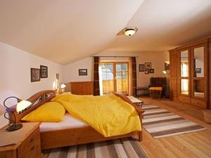 a bedroom with a large bed with a yellow blanket at Chalet Alpinum in Sankt Anton am Arlberg