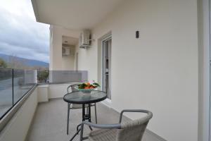 a small table and chairs on a balcony with a view at Evas Rooms in Nei Poroi