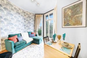 a living room with a blue couch and a table at Relaxing Flat in London - Sleeps 6 - Garden in Greenford