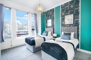two beds in a room with green walls and windows at Relaxing Flat in London - Sleeps 6 - Garden in Greenford