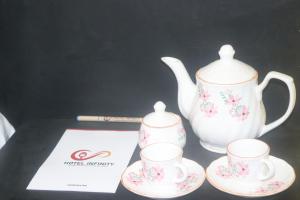 un set de té con dos tazas y una tetera en Hotel Infinity, en Rajgir