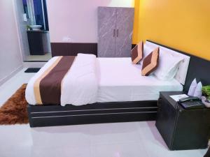 1 dormitorio con 1 cama con sábanas y almohadas blancas en Hotel Infinity, en Rajgir