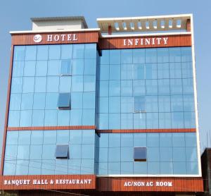un edificio de hotel con un cartel en él en Hotel Infinity, en Rajgir