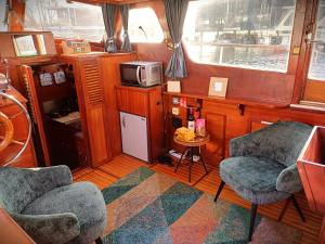 a kitchen with two chairs and a microwave in a boat at Motorjacht Flint in Amsterdam