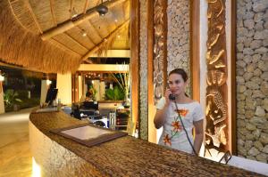 a woman standing at a counter talking on a microphone at Princesa Garden Island Resort and Spa in Puerto Princesa City