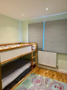a small room with a bunk bed and a window at Entire house with a large lounge in Leverstock Green