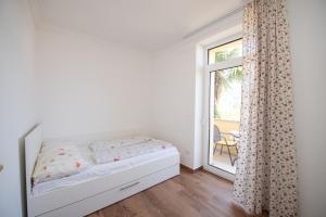 a white bedroom with a bed and a window at Apartment in Ika with Seaview, Balcony, Air condition, WIFI 5025-4 in Ika