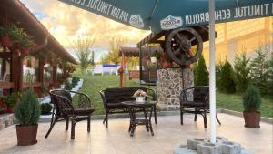 a patio with chairs and a table and an umbrella at Casa MagicPlace in Viile Satu Mare
