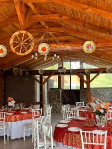 a banquet hall with tables and white chairs and wooden ceilings at Casa MagicPlace in Viile Satu Mare
