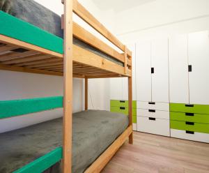 una camera con 2 letti a castello con accenti verdi di FRONTE MARE a Pesaro