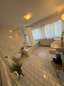 a bathroom with a tub and a toilet and a sink at Hotel Bitzer Backnang in Backnang