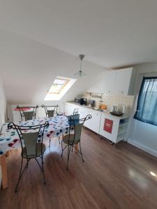 a room with a table and chairs and a kitchen at Sunshine Apartment Velence in Velence