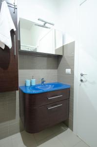 un bagno con un lavandino blu e uno specchio di FRONTE MARE a Pesaro