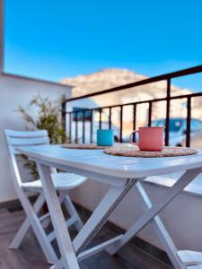 una mesa en un balcón con 2 tazas y sillas en Queen of the Beach, en Bar