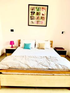 a bed in a bedroom with two night stands and two tables at Homestay-a better living in Lucknow