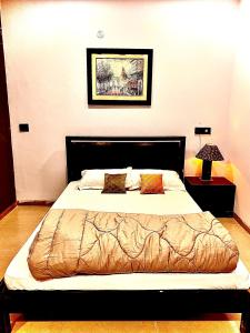 a bedroom with a large bed with a bedspread and pillows at Homestay-a better living in Lucknow