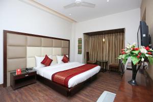 a hotel room with a large bed and a table at OYO Asian Hospitality Near Aravali Biodiversity Park in Gurgaon