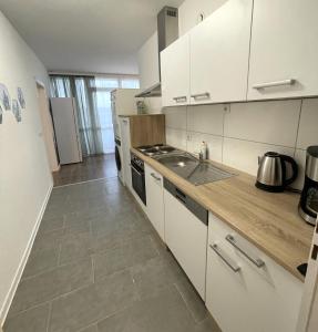 魯爾河畔米爾海姆的住宿－Große 3-Zimmer Wohnung, zentrale Lage.，厨房配有白色橱柜和炉灶烤箱。