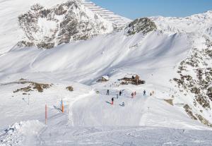 a group of people skiing down a snow covered mountain at Cozy Loft in the Alps of Zillertal in Schwendau