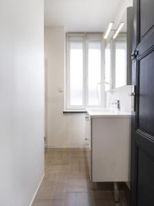 een witte keuken met een wastafel en een raam bij Residence Louis Quartier Des Lilas in Vittel