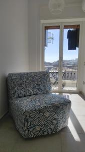 une chaise dans une pièce avec balcon dans l'établissement Neapolitan Skyscraper Suites, à Naples