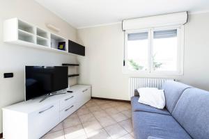 ein Wohnzimmer mit einem blauen Sofa und einem Flachbild-TV in der Unterkunft Legnano 20 in Bollate