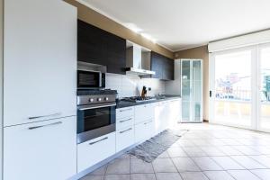 eine Küche mit weißen Geräten und einem großen Fenster in der Unterkunft Legnano 20 in Bollate