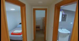 a bathroom with a bedroom with a bed and a sink at ''Lake House Jana'' Ramsko Jezero in Prozor