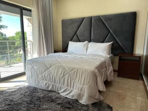 - une chambre avec un grand lit et une grande tête de lit dans l'établissement Roma Apartments, à Lusaka