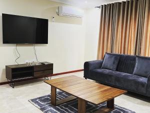 - un salon avec un canapé en cuir noir et une table basse dans l'établissement Roma Apartments, à Lusaka