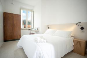 a bedroom with a white bed with two towels on it at Hotel Leon D'Oro in Alfedena